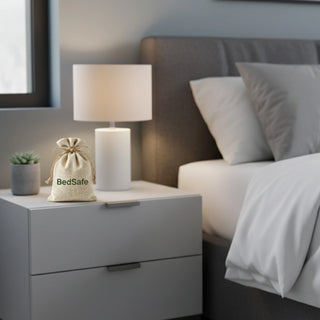 BedSafe crystal pouch 110gm placed on a bedroom nightstand beside a lamp