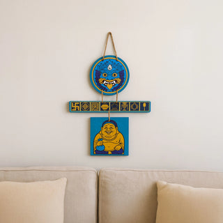 Blue wall hanging for protection and calmness with Kirtimukh and Laughing Buddha, hung above living room sofa