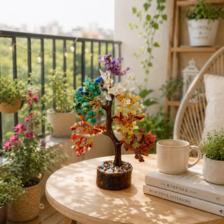 7 Chakra crystal tree displayed on an outdoor balcony table with coffee mug and plants