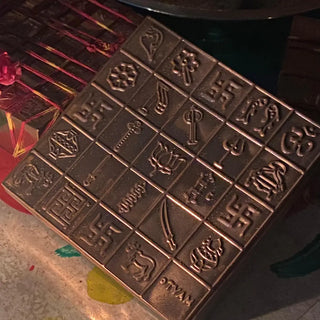 Close-up of Garbha Manjusha copper box showing engraved swastik, lotus, conch and vastu symbols