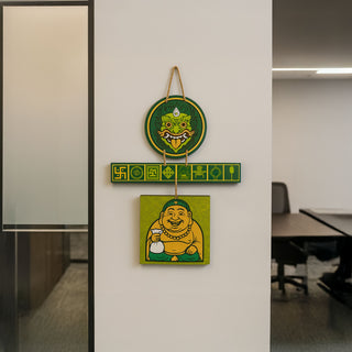 Green Suraksha Kavach wall hanging with Kirtimukh and Laughing Buddha for growth and protection, hung in office space