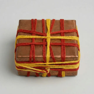 Padma Manjusha copper Vastu box wrapped in red and yellow thread on white background